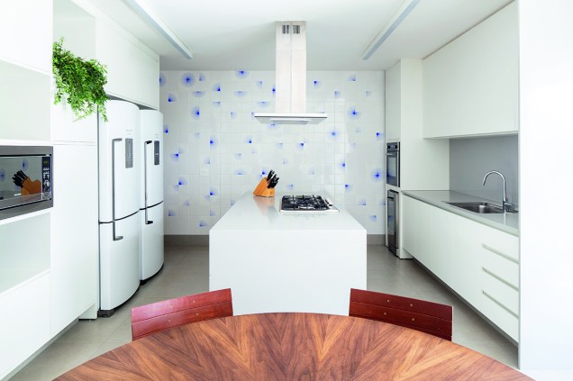Com ilha de 1 x 2,30 m, a cozinha ganhou azulejos decorados na parede (linha Flor Partida, do Atelier Leopardi Esperante). Bancadas de Silestone (Cosentino, no padrão Alumínio Nube). Armários da Florense.