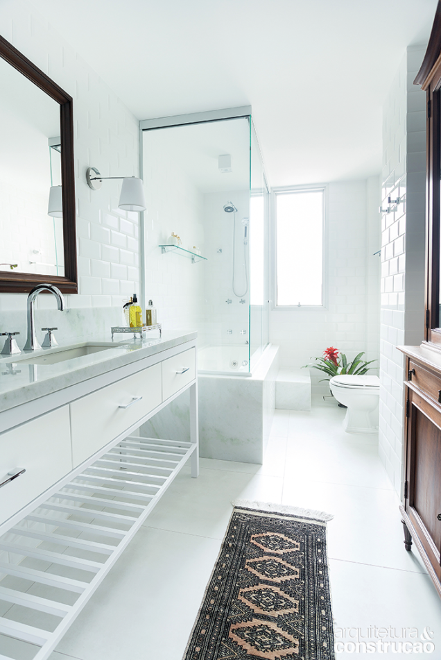 A cristaleira (à dir.) e a arandela reforçam o estilo antiguinho do banheiro de hóspede, concebido pelo arquiteto Marcelo Salum. A bancada e o volume da banheira são de mármore madrepérola (Americana Granitos do Brasil).