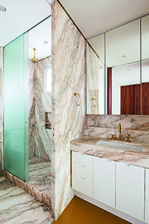 Com área de banho e lavatório separados um do outro, o banheiro revestido de mármore Striatto Mol (Pedras Bellas Artes), otimiza o dia a dia. Metais da Deca.