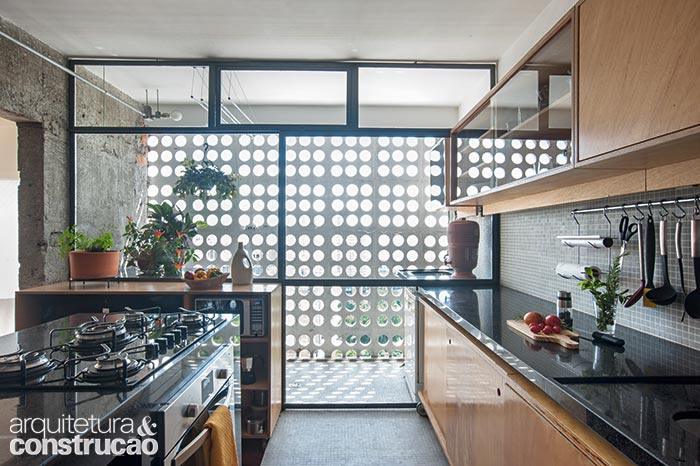 A fim de levar claridade à cozinha, posicionada onde ficava a área de serviço, os arquitetos do mgdg instalaram uma discreta armação metálica diante dos cobogós originais do prédio. Composta de porta de correr e basculantes, a estrutura (Iron Logic) ganhou tinta cinza-chumbo, vidros temperados e laminados.