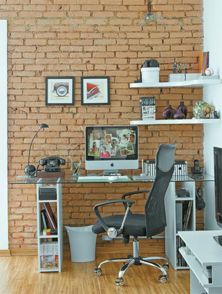 Um retalho de vidro temperado compõe o tampo da mesa deste home office. E dez placas de MDF viraram o suporte que o apoiam. O móvel reúne itens do dia a dia e, em uma das pontas, deixa os fones de ouvido à mão. Durante a obra, belos tijolos foram descobertos e morador resolveu deixá-los à vista. Um retalho de vidro temperado compõe o tampo da mesa deste home office. E dez placas de MDF viraram o suporte que o apoiam. O móvel reúne itens do dia a dia e, em uma das pontas, deixa os fones de ouvido à mão. Durante a obra, belos tijolos foram descobertos e morador resolveu deixá-los à vista.