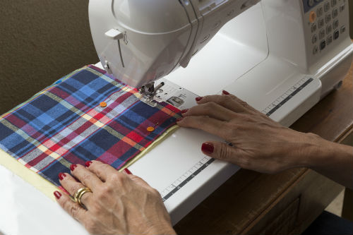 A seguir, una-os, costurando por uma das laterais (na máquina, como fizemos aqui, ou à mão) e deixando uma pequena sobra, de cerca de 0,5 cm. Repita a operação com os outros pares xadrez-amarelo, até obter 4 duplas.