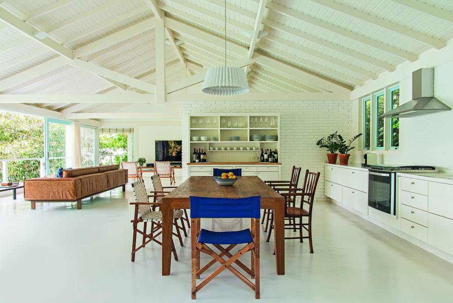 Um espaço único e integrado comporta os ambientes de estar e convivência, onde o piso é de cimento queimado tingido de branco, feito na obra e sem juntas aparentes(execução da Preo Engenharia). A cozinha se resume à bancada junto à parede, com armários desenhados pelo arquiteto Mauro Cid e executados pela Marcenaria Julio Awagakubo. O azul das portas e esquadrias de madeira é um esmalte sintético à base d´água (Suvinil, ref. Céu Sereno).