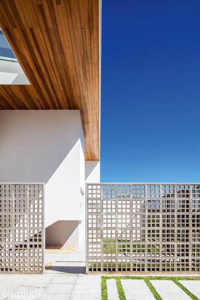 Ao alocar a garagem perto da entrada desta casa em Brasília, o escritório BLOCO Arquitetos subiu dois muros, de 3 m e 3,40 m de comprimento por 2,20 m de altura, com cobogós de concreto (Premoldado Brasil). Ancorados nos pilares da fachada e do portão, eles ganharam reforço entre fiadas e uma moldura de chapas de aço dobradas.
