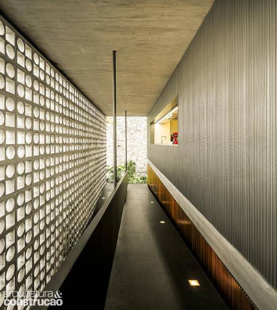 Vizinho da rampa de acesso, o paredão de 5,70 x 16,80 m marca a transição entre exterior e interior na lateral desta morada paulistana. Projeto arquitetônico do studio mk27 e de Fernanda Neiva (Galeria Arquitetos) – que desenhou os exclusivos blocos de concreto, moldados pela Gesso Goes –, e interiores de Diana Radomysler.