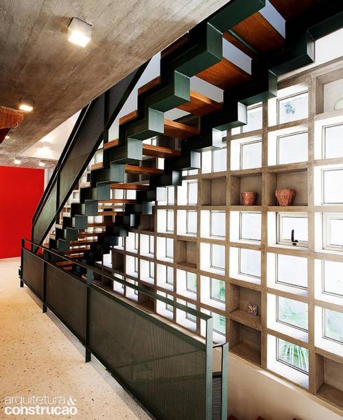 Nesta residência em São Paulo, o escritório Perkins+Will bolou uma solução capaz de integrar os três níveis do vão da escada: a alternância de diferentes elementos pré-moldados de concreto (Winblok) ao longo dos 9 m de altura. Modelos com fundo funcionam como estante e se revezam com unidades fechadas com vidro fixo ou basculante.