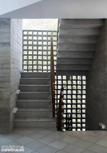 Ventilação era um fator primordial neste projeto em São Sebastião, no litoral paulista. Para cumprir o objetivo, o arquiteto Gustavo Calazans elaborou um fechamento que alterna vidraça e caixilhos de concreto (NeoRex, com e sem vidro encaixado) e abraça os pilares da escada, deixando um vão de 10 cm nas laterais para a passagem do ar.