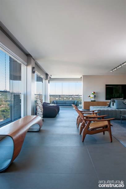 Quando a família contratou o escritório Storrer Tamburus para pensar a obra do apartamento de 352 m² em São Paulo, um dos objetivos era dar mais amplitude à ala social. “Propusemos incorporar completamente a varanda de 80 m², gerando um grande espaço aberto”, explica o arquiteto Fábio Storrer. Uma das sacadas da nova distribuição foi conectar tudo, a exemplo do sofá único, que pode ser usado em ambos os lados, atendendo, ao mesmo tempo, o estar e a área da TV. O escritório também foi incluído nesse trecho. Piso e forro foram nivelados e a varanda em L ganhou proteção de vidro (Sistema Vão Livre), com folhas laminadas de 10 mm de espessura em perfis de alumínio.