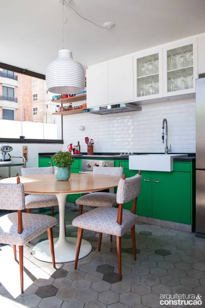 Uma churrasqueira e nada mais. Assim era constituída a varanda de 18 m² do apartamento em São Paulo. Como a família é aficionada por gastronomia e a cozinha era pequena, tiveram a ideia de criar uma segunda área no terraço para preparar pratos e receber convidados. Responsável pelo projeto, o DT Estudio nivelou o piso e retirou a porta de correr que isolava o local, instalando um batente de madeira. Na parede, azulejos Liverpool White (Portobello). Marcenaria da Real Móveis.