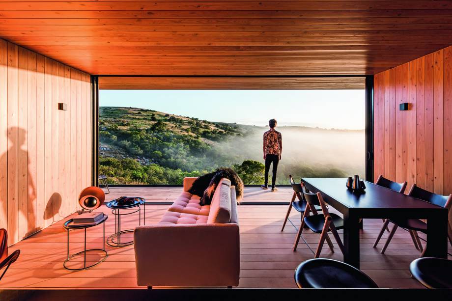 EDE, MALDONADO, URUGUAI, 2015: Dois módulos executados com estrutura metálica leve (light steel frame) compõem este projeto apoiado sobre muros de pedra erguidos com técnicas locais. “A experiência é de viver numa varanda aberta e protegida, em franca interação com o entorno”, diz Luciano. Tábuas de ipê revestem paredes e forro. No piso, entrou a grapia. “O mais interessante será ver como as madeiras irão mudando de cor com o tempo.”