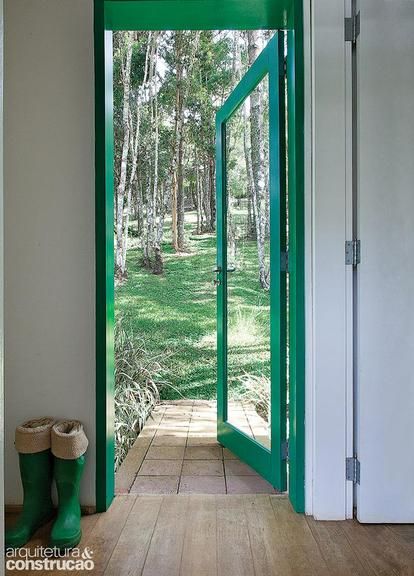 Aberta para o jardim, esta porta se mescla com a paisagem ao redor