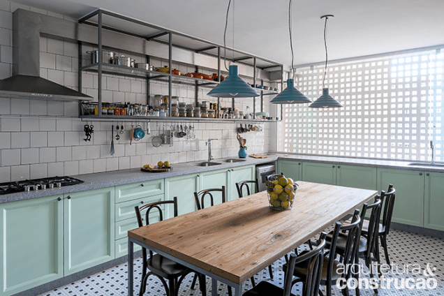 A fim de aproximar os convidados dos anfitriões, levando todos a se sentirem em casa, a mesa de jantar foi inserida na cozinha – ampliada no projeto do escritório Bloco Arquitetos. Entre os elementos novos e antigos em harmonia na gostosa área de receber estão o armário superior vazado de metalon, para maior leveza visual, e o duto aparente da coifa. A bancada é de granito levigado, as pastilhas do piso são hexagonais e há azulejos tradicionais (15 x 15 cm) nas paredes. A fim de aproximar os convidados dos anfitriões, levando todos a se sentirem em casa, a mesa de jantar foi inserida na cozinha – ampliada no projeto do escritório Bloco Arquitetos. Entre os elementos novos e antigos em harmonia na gostosa área de receber estão o armário superior vazado de metalon, para maior leveza visual, e o duto aparente da coifa. A bancada é de granito levigado, as pastilhas do piso são hexagonais e há azulejos tradicionais (15 x 15 cm) nas paredes.