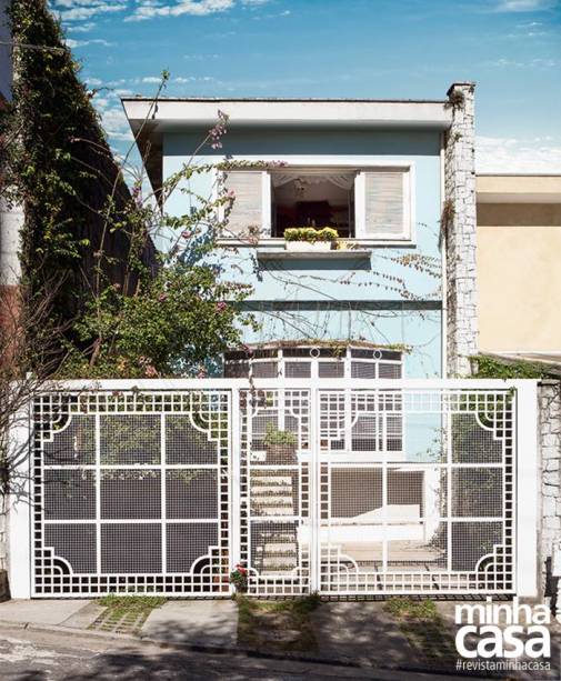 A construção é reta e o beiral, largo. Com traços típicos dos anos 1970, hoje este sobrado se destaca por suas esquadrias, a começar pelo portão todo trabalhado. A trama permite ver que a sala recebeu uma estilosa bay window, janela com faces salientes comum nos Estados Unidos. No tamanho 2,25 x 1,50 m, da Esquadrimetal. Nas paredes, a tinta azul (Azulejo de Casa, ref. B333, da Suvinil, aos poucos está sendo coberta pelas trepadeiras falsa-vinha e jasmim-dos-açores.