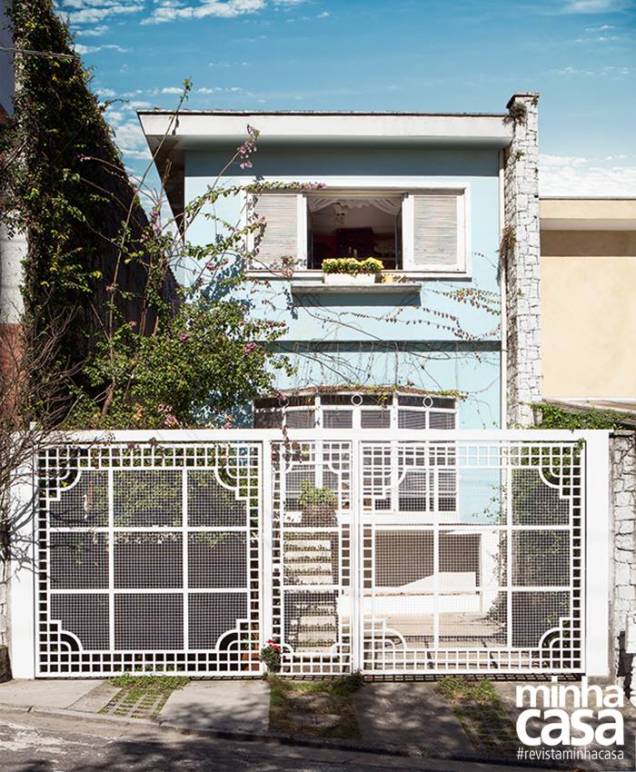 A construção é reta e o beiral, largo. Com traços típicos dos anos 1970, hoje este sobrado se destaca por suas esquadrias, a começar pelo portão todo trabalhado. A trama permite ver que a sala recebeu uma estilosa bay window, janela com faces salientes comum nos Estados Unidos. No tamanho 2,25 x 1,50 m, da Esquadrimetal. Nas paredes, a tinta azul (Azulejo de Casa, ref. B333, da Suvinil, aos poucos está sendo coberta pelas trepadeiras falsa-vinha e jasmim-dos-açores. A construção é reta e o beiral, largo. Com traços típicos dos anos 1970, hoje este sobrado se destaca por suas esquadrias, a começar pelo portão todo trabalhado. A trama permite ver que a sala recebeu uma estilosa bay window, janela com faces salientes comum nos Estados Unidos. No tamanho 2,25 x 1,50 m, da Esquadrimetal. Nas paredes, a tinta azul (Azulejo de Casa, ref. B333, da Suvinil, aos poucos está sendo coberta pelas trepadeiras falsa-vinha e jasmim-dos-açores.