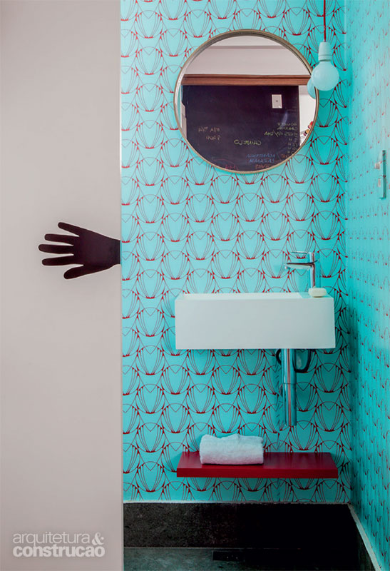 O estúdio Figueroa.arq transformou o antigo banheiro de empregada no divertido lavabo, com papel de parede e adesivo indicando a abertura da porta de correr.