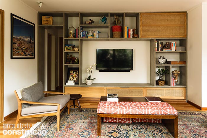 Solução única para a sala de estar com TV, a estante de concreto acompanha o pé-direito de 2,58 m do apartamento reformado pelo dt.estudio, dos arquitetos Thais Aquino, Luis Bernardini e Marcelo Nunes. Chumbado na parede, o esqueleto foi preenchido na obra e protegido com seladora. Os trechos tampados com palhinha camuflam fios e equipamentos sem prejudicar a ventilação interna. “O mais difícil na decisão pelo cimento foi obter as prateleiras finas”, conta a arquiteta Thais Aquino. A execução levou um mês para chegar aos 3 cm de espessura.