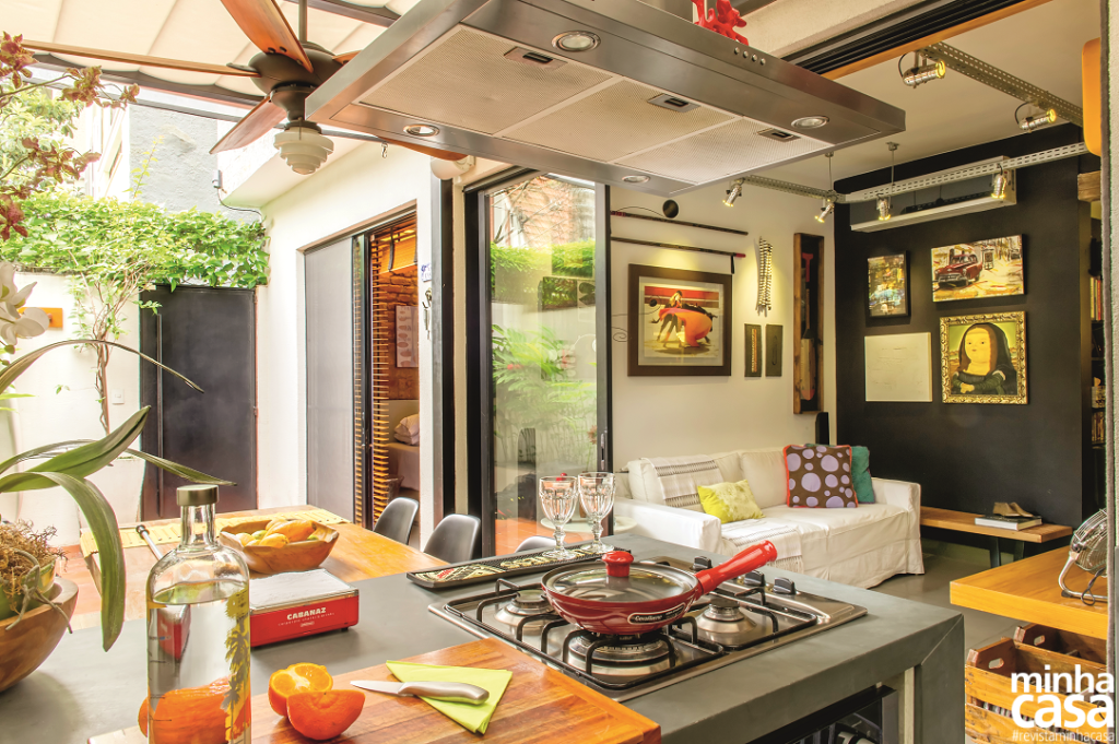 Cozinha na varanda e jardim criam clima de casa em apartamento térreo