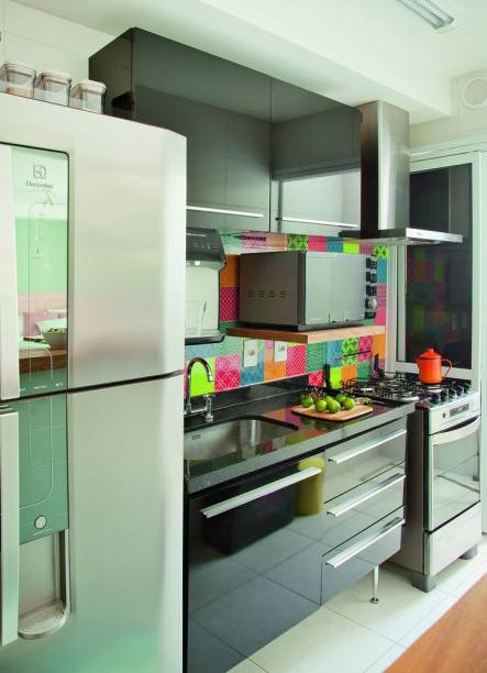 <span>Cores marcantes foram usadas na cozinha. Os adesivos com estampas que remetem a ladrilhos hidráulicos (Mix Colorines. Grudado) escondem os azulejos lisos sem graça acima da pia. “Apliquei o produto há dois anos e meio e ele não descolou!”, comemora Tamires. Projeto das arquitetas Tamires Roccon e Adriana Navatta.</span> <span>Cores marcantes foram usadas na cozinha. Os adesivos com estampas que remetem a ladrilhos hidráulicos (Mix Colorines. Grudado) escondem os azulejos lisos sem graça acima da pia. “Apliquei o produto há dois anos e meio e ele não descolou!”, comemora Tamires. Projeto das arquitetas Tamires Roccon e Adriana Navatta.</span>