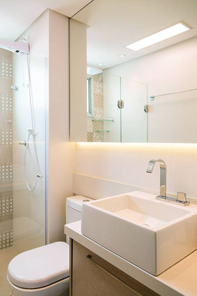 <span>Para conferir um visual sofisticado ao banheiro, a principal superfície do boxe recebeu um estiloso mosaico de azulejos com estampas de grafismos em branco e dourado (Patchwork Gold, da Decortiles. Máxxima Revestimentos). As demais paredes, por sua vez, foram cobertas com um porcelanato liso fosco (White Plain Matte, da Portinari. Máxxima Revestimentos). Projeto da arquiteta Bárbara Dundes.</span> <span>Para conferir um visual sofisticado ao banheiro, a principal superfície do boxe recebeu um estiloso mosaico de azulejos com estampas de grafismos em branco e dourado (Patchwork Gold, da Decortiles. Máxxima Revestimentos). As demais paredes, por sua vez, foram cobertas com um porcelanato liso fosco (White Plain Matte, da Portinari. Máxxima Revestimentos). Projeto da arquiteta Bárbara Dundes.</span>