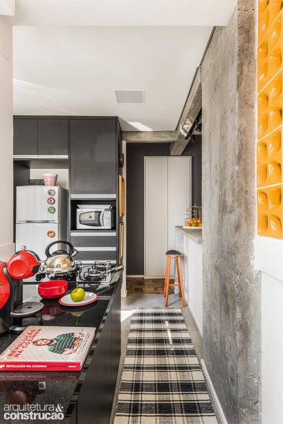 A cozinha ganhou valioso aliado no dia a dia: o trecho da bancada com armários, a lava-louça e o fogão (instalado na ponta). Apesar de o acréscimo de espaço não ser grande, a sensação no ambiente mudou – não é raro haver amigos sentados em banquetas no novo corredor.