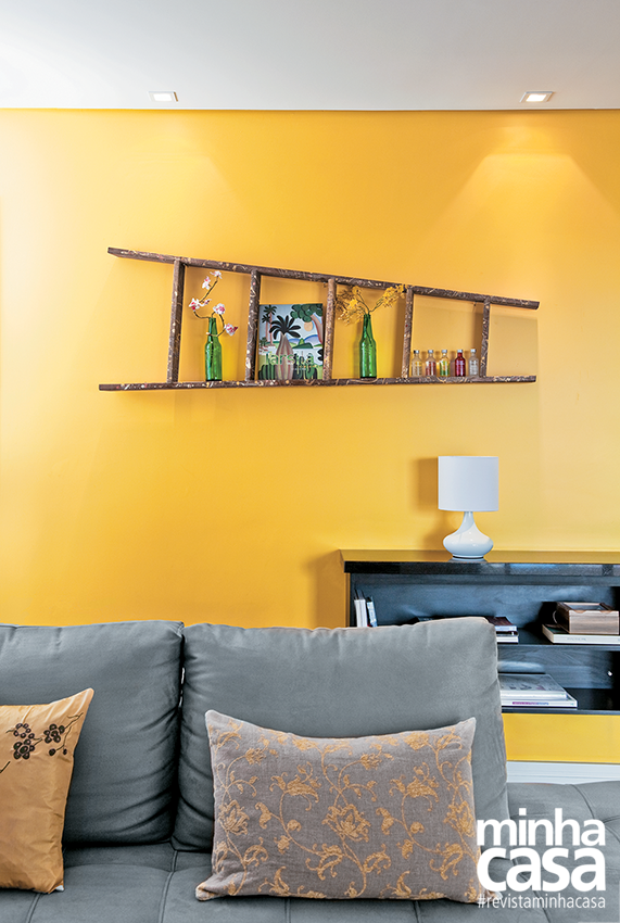 O amarelo dá vida à sala. O destaque da pintura é o amarelo (Banana Madura, da Coral), que enche o estar de personalidade. Na parede colorida, um elemento inusitado atrai os olhares: uma escada deitada que apoia enfeites. O aspecto rústico contrasta com os itens modernos reinantes. Sofá com chaise, 2,90 x 1,05 (1,70 m aberto) x 0,70 m, da Planejamento Móveis.