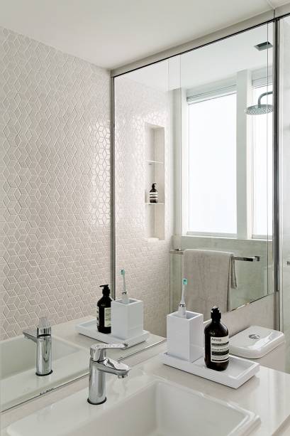 O banheiro exibe bancada de Silestone Yukon (MSA), misturador monocomando Focus (Hansgrohe) e pastilhas Cúbicas (Portobello), com efeito tridimensional.
