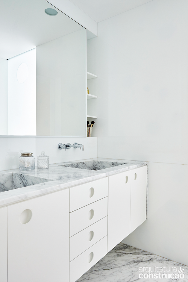 Os banheiros são confortáveis, porém minimalistas no visual. O do casal recorre ao mármore carrara (Mont Blanc Mármores) para compor não apenas o piso como o tampo com duas cubas e gabinete (Marvelar).