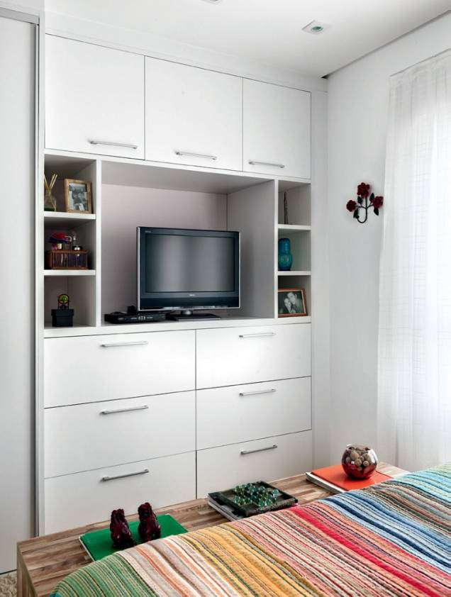 <span>O desenho dos móveis responde pelo bom uso da metragem do quarto. A parede em frente à cama é preenchida pelo armário e por uma marcenaria embutida, com 51 cm de profundidade, que faz as vezes de estante. “Aproveitei o pé-direito inteiro e incluí um nicho grande para a TV, vãos abertos e fechados e, ainda, seis gavetões, que deixam tudo na mais perfeita ordem”, destaca a designer de interiores Ana Maria Mouawad Queiroga, do Studio da Ana,</span> <span>O desenho dos móveis responde pelo bom uso da metragem do quarto. A parede em frente à cama é preenchida pelo armário e por uma marcenaria embutida, com 51 cm de profundidade, que faz as vezes de estante. “Aproveitei o pé-direito inteiro e incluí um nicho grande para a TV, vãos abertos e fechados e, ainda, seis gavetões, que deixam tudo na mais perfeita ordem”, destaca a designer de interiores Ana Maria Mouawad Queiroga, do Studio da Ana,</span>