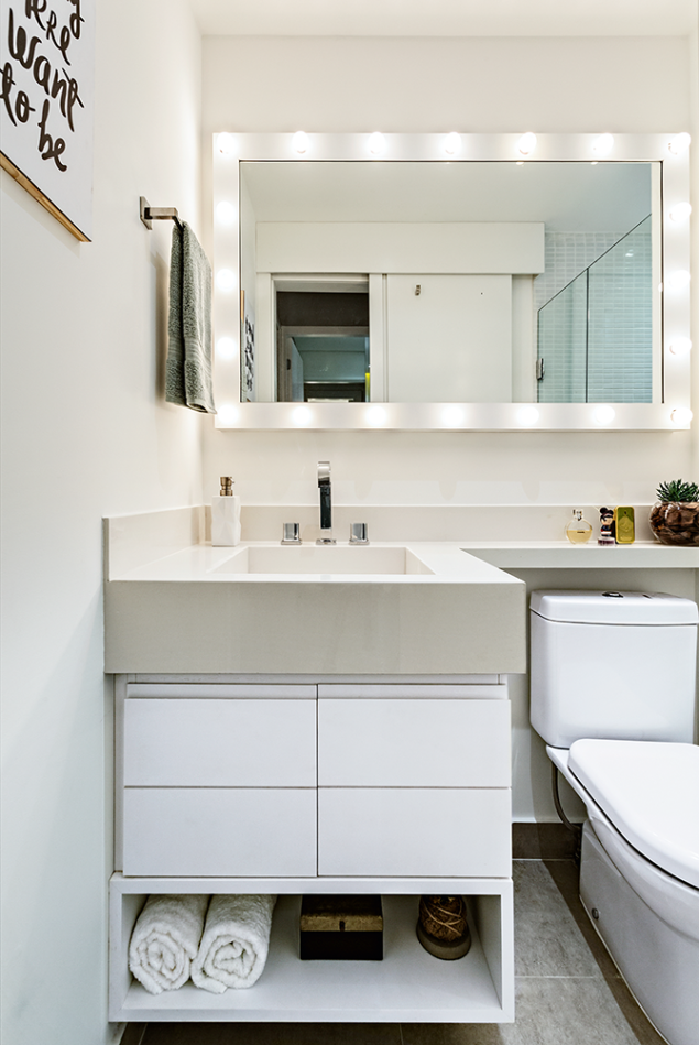 <span>No banheiro social, o espelho é o protagonista. A moradora sonhava com um espaço para se maquiar e as arquitetas o fizeram. Com 1,16 x 0,80 m ele tem moldura de MDF laminado (Branco TX, da Duratex) e 20 lâmpadas bolinha. No boxe, pastilhas brancas (2,5 x 5 cm), da Atlas (Pastilhart). Projeto do Doob Arquitetura.</span> <span>No banheiro social, o espelho é o protagonista. A moradora sonhava com um espaço para se maquiar e as arquitetas o fizeram. Com 1,16 x 0,80 m ele tem moldura de MDF laminado (Branco TX, da Duratex) e 20 lâmpadas bolinha. No boxe, pastilhas brancas (2,5 x 5 cm), da Atlas (Pastilhart). Projeto do Doob Arquitetura.</span>