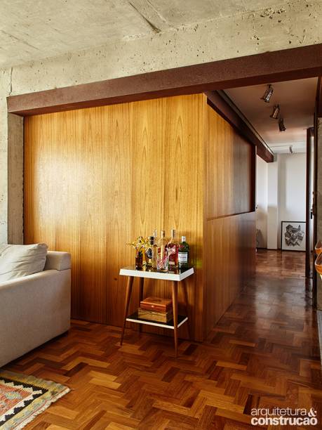Com hóspedes: duas portas de correr de freijó – a mesma madeira de toda a marcenaria da casa – escorregam da lateral esquerda a fim de criar a situação para visitas, formando uma caixa ao encontrar o armário de 0,60 x 3,15 m. Este móvel grande faz as vezes de divisória, demarcando um pequeno corredor que leva ao banheiro.