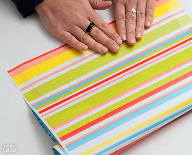 2. Vire e vá puxando aos poucos, até terminar de colar o papelão.