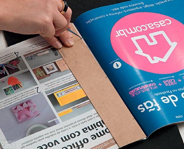 11. Pegue a primeira revista, abra-a no meio (onde os grampos ficam aparentes) e, com a ajuda do gabarito B, fure-a com o agulhão nas três marcações.