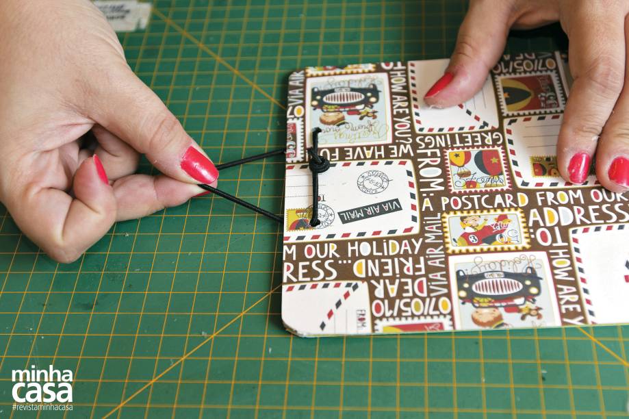 7. Para o fecho, faça dois furos com o furador (um a cerca de 4 cm do outro) perto da extremidade de uma das placas de papelão. Passe o elástico entre eles e dê um nó.