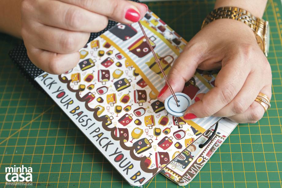 8. Na outra placa, à mesma distância da extremidade, crie dois furinhos com a agulha (a 1 cm um do outro). Use agulha e linha para prender o botão na placa.