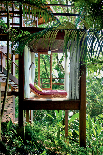 No nível dos quartos, sob a varanda dos fundos, a área de relax oferece vista plena até em dias chuvosos. Ao manter a casa longe do solo, os arquitetos preservaram a madeira da umidade constante.