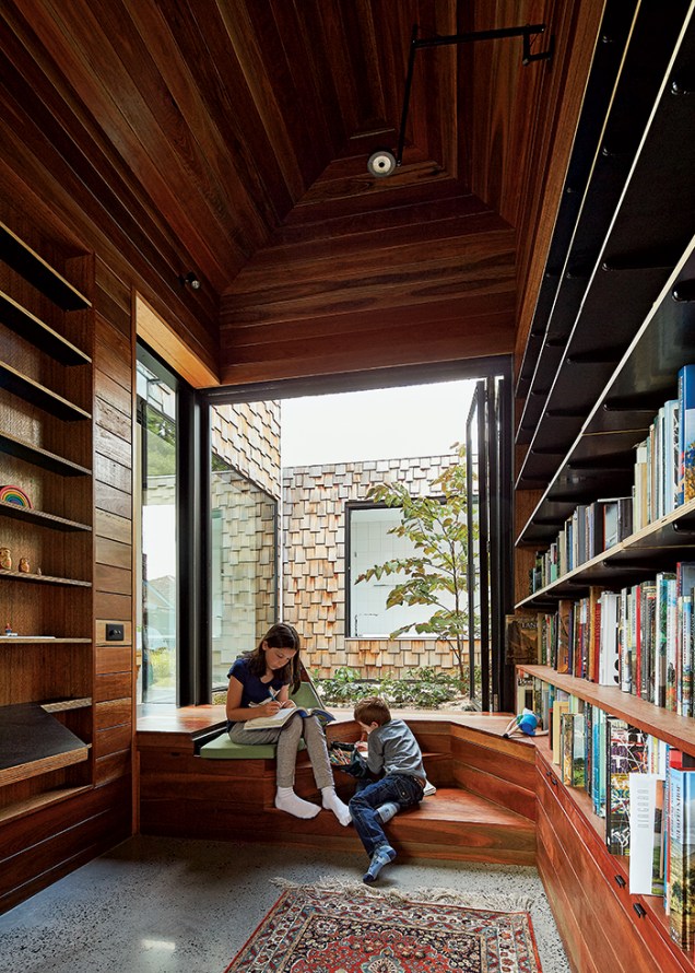 Uma madeira escura, conhecida na Austrália como spotted gum, reveste a biblioteca do piso ao teto. O local foi levemente rebaixado para que os assentos se nivelassem ao jardim.