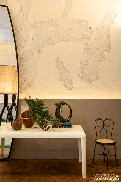 Paredes com textura: ao valorizar a imperfeição do descascado original das paredes, o arquiteto Osvaldo Tenório expôs a beleza da arquitetura bruta. Na parte inferior, um lambri coberto com papel de parede esconde fitas de led que evidenciam o encontro de texturas.