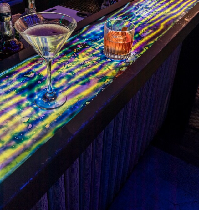 O bar no segundo piso possui uma superfície lúdica criada com líquidos coloridos que se movimentam com o toque.