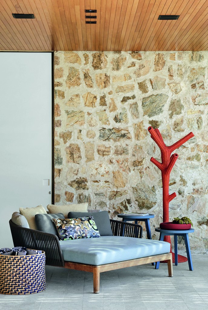 Ambiente externo com revestimento de pedra madeira na parede