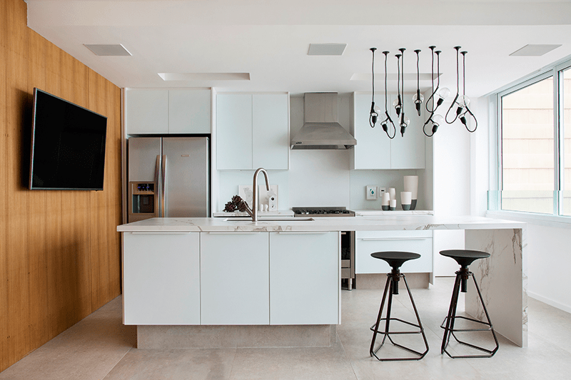 A composição e a disposição dos armários da cozinha foram escolhas do arquiteto com base nas opções do fornecedor (Favo Móveis). Ele preferiu peças com corpo de MDF revestido de laminado com microtextura, além de portas de vidro acidato fosco (com pintura branca), que oculta as marcas de dedos. Internamente, divisórias de inox facilitam a higienização. Projeto: Stduio Ro+Ca.