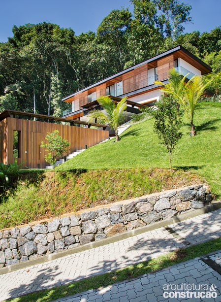 Os materiais demarcam a setorização desejada pelo arquiteto. Embaixo, fica o bloco de lazer, revestido pelo ripado de cumaru (Cavazzoni Marcenaria). O térreo ganhou pedra do tipo canjiquinha no entorno, para parecer um volume sólido que ampara o andar superior– muito fluido, marcado pelos brises. Imperceptível, a cobertura (1% de inclinação) reúne laje com manta asfáltica ardosiada e argila expandida para barrar o calor.