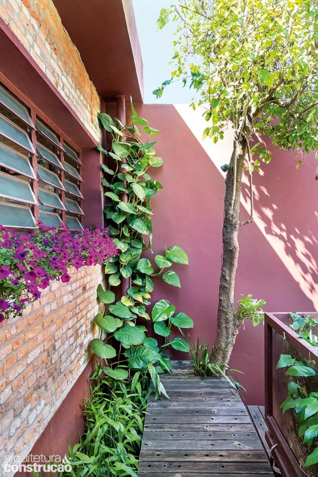 Petúnias adicionam cor à entrada da casa, cuja área verde soma 15 m².
