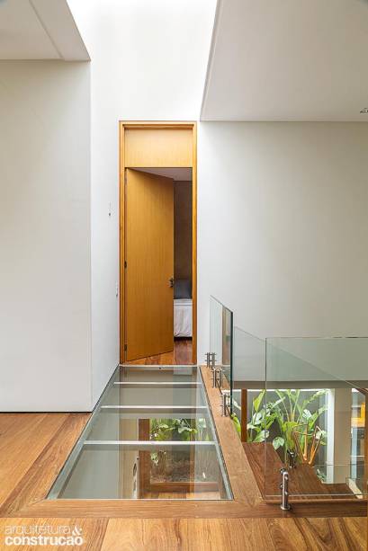 Na saída da escada, o piso de vidro laminado sustentado por estrutura de aço inox deixa o hall, logo embaixo, naturalmente claro. “Gosto de usar a iluminação zenital para banhar de forma homogênea os ambientes de luz”, detalha o arquiteto. Na saída da escada, o piso de vidro laminado sustentado por estrutura de aço inox deixa o hall, logo embaixo, naturalmente claro. “Gosto de usar a iluminação zenital para banhar de forma homogênea os ambientes de luz”, detalha o arquiteto.