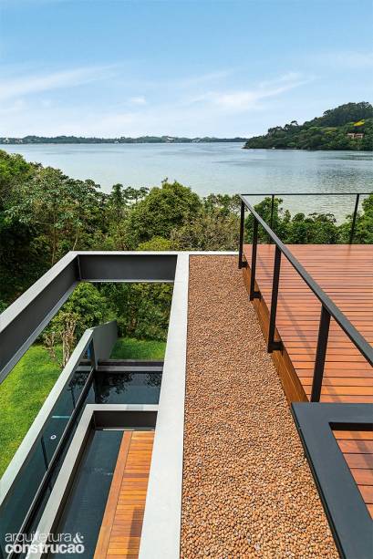 Protegido pelo guarda-corpo de aço, o deck de ipê (Pau-Pau Pisos de Madeira), eleva-se 50 cm para embutir as vigas invertidas da laje de cobertura. Protegido pelo guarda-corpo de aço, o deck de ipê (Pau-Pau Pisos de Madeira), eleva-se 50 cm para embutir as vigas invertidas da laje de cobertura.