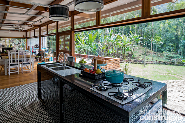 Só a cozinha recebeu piso cerâmico, assentado sobre placas cimentícias. Para o restante da área, elegeu-se o assoalho de garapeira. Com cooktop e pia com duas cubas, a ilha também funciona como bar.