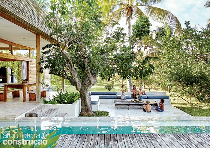 A piscina se vê cercada de agradáveis áreas de estar, como este terraço com sofá de alvenaria. O pínus da estrutura e do deck recebeu tratamento sob pressão de ação fungicida e inseticida. “Para obter o visual desgastado, não apliquei nenhum tipo de óleo ou seladora adicional”, conta Casper.