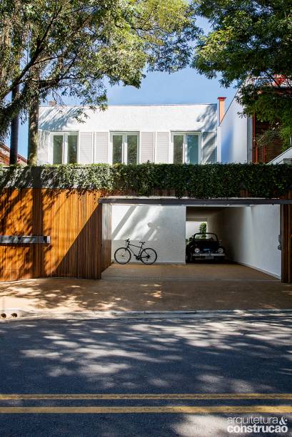 Sobre o muro da entrada, bandejas de chapa metálica (mesmo material do passa-cartas e do puxador) abrigam as heras, que pendem sobre o portão de freijó. Sobre o muro da entrada, bandejas de chapa metálica (mesmo material do passa-cartas e do puxador) abrigam as heras, que pendem sobre o portão de freijó.