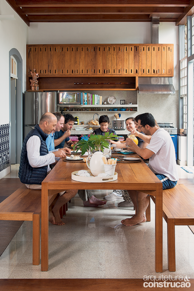 O granito da entrada repete-se sob a mesa de jantar, executada pela Marcenaria da Mangueira, assim como os armários da cozinha.