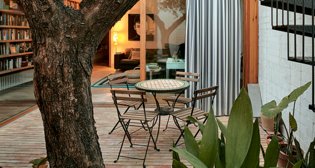 Entre sala e cozinha, conectando as duas metades do térreo, o pátio principal tem uma oliveira como protagonista. A escada externa leva ao terraço descoberto.