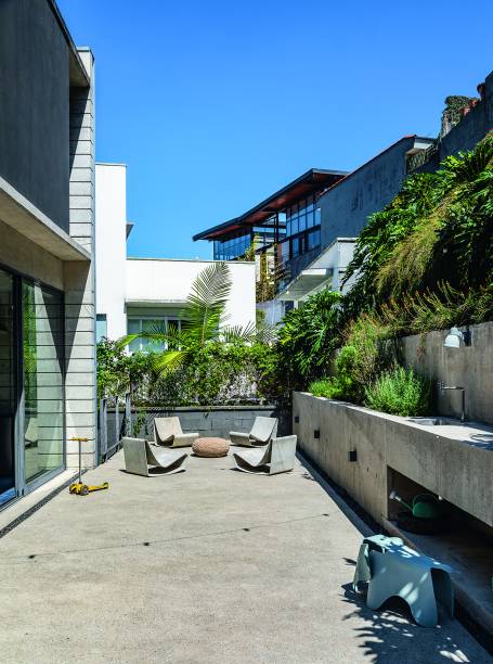 O  terraço de 3,70 x 13,10 m à frente da cozinha assume o piso de concreto polido, mesmo material dos platôs com hortas, a 80 cm de altura. “Essa medida traz conforto durante o plantio e a manutenção”, ensina Fernanda. Pufe da Codex Home.